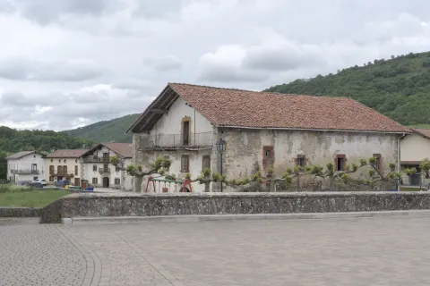 Caserío tradicional en Bizkarreta-Gerendiain, con balconada de madera, junto a plaza del frontón.