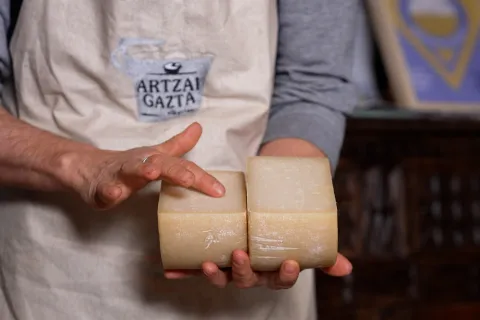 Productora de experiencia Beloki Mendia mostrando  queso, en Uztegui, Plazaola-Sakana-Ultzamaldea.