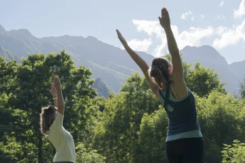 Dos personas practicando yoga al aire libre en valle de Araitz, parte de la experiencia de Ekino Aukera.