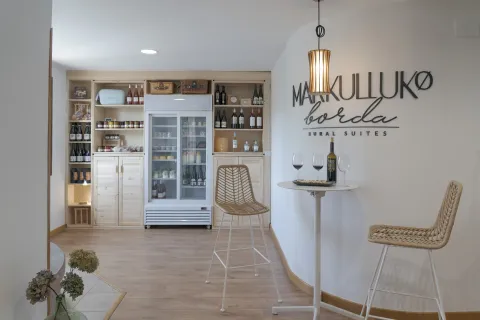 y tienda en Markulluko Bordia Rural Suites, en Elizondo Baztan-Bidasoa, con vitrinas de botellas de vino y productos locales.