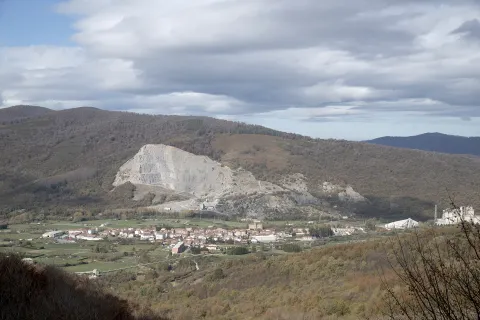 Vista panorámica de Olazti con cantera de cal blanca al fondo, rodeada de bosques.