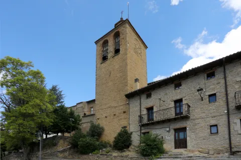 Iglesia de San Vicente en Sada con torre de piedra arenisca y campanario.