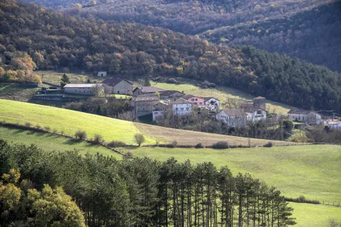 Pueblo de Atez rodeado de bosques y prados en el valle.