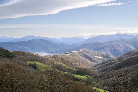 Valle verde con caserio tradicional y montaña al fondo en los valles de Baztan Bidasoa.
