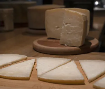 Artisanal cheese cut into wedges on a wooden board at the Ekia cheese dairy, in the Navarran Pyrenees.