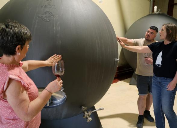 Cata de vino en bodega Eslava con visitas observando barriles de envejecimiento.