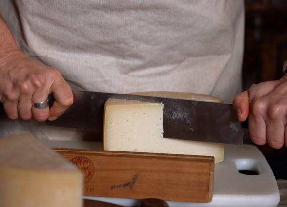 Productora de experiencia Beloki Mendia mostrando  corte de queso, en Uztegui, Plazaola-Sakana-Ultzamaldea.