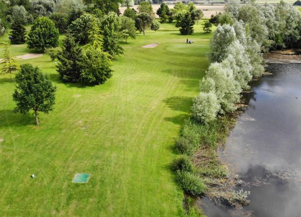 n campo de golf Lizaso, valle de Ultzama, con prados verdes y bosque de fondo, en Plazaola-Sakana-Ultzamaldea.