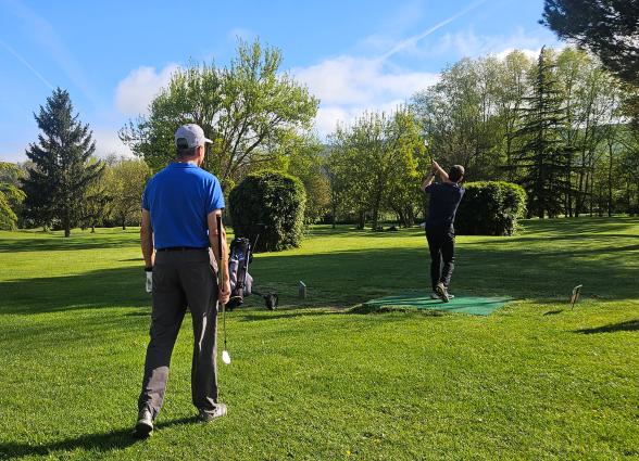 po de golf Lizaso, valle de Ultzama, con prados verdes y bosque de fondo bajo cielo despejado, en Plazaola-Sakana-Ultzamaldea.