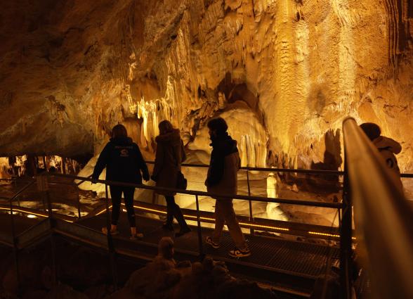 Visitantes recorriendo pasarela en cueva durante experiencia Cueva de Mendukilo en Astiz, Plazaola-Sakana-Ultzamaldea.