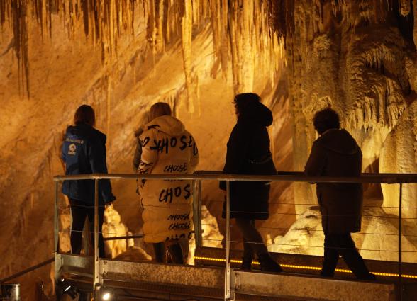 Visitantes recorriendo pasarela en cueva durante experiencia Cueva de Mendukilo en Astiz, Plazaola-Sakana-Ultzamaldea.