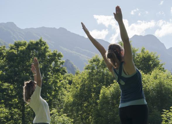 Dos personas practicando yoga al aire libre en valle de Araitz, parte de la experiencia de Ekino Aukera.