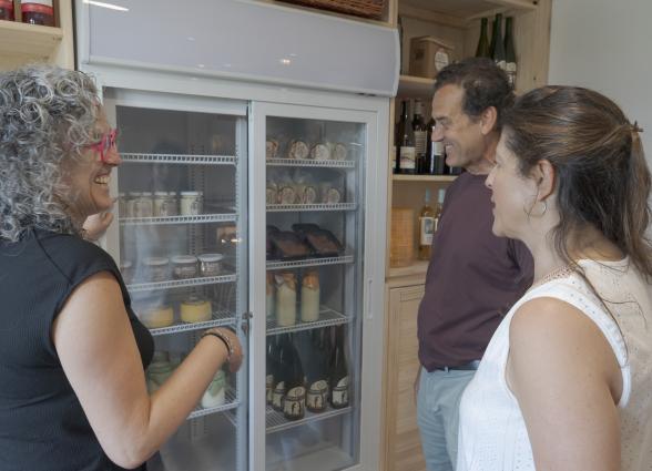 Visitantes de Markulluko Borda Rural Suites atienden a las explicaciones de productos locales que venden ahí.