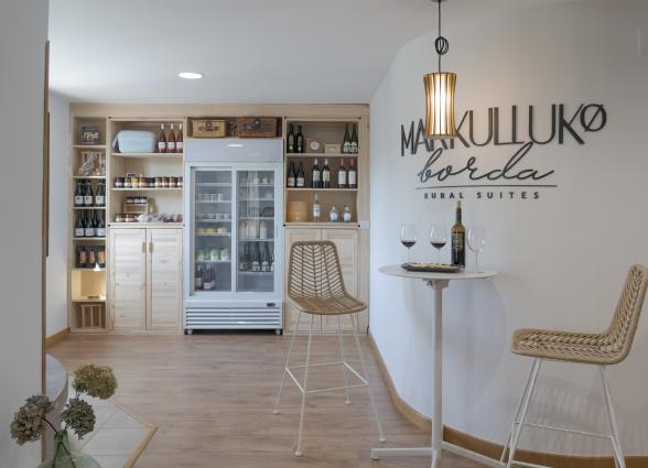 tienda en Markulluko Bordia Rural Suites, en Elizondo Baztan-Bidasoa, con vitrinas de botellas de vino y productos locales.