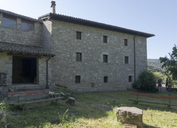 Casa Perotx Enea en Adoain, casa de piedra en la Comarca de Sangüesa, con jardin con bancos de madera en la parte trasera.