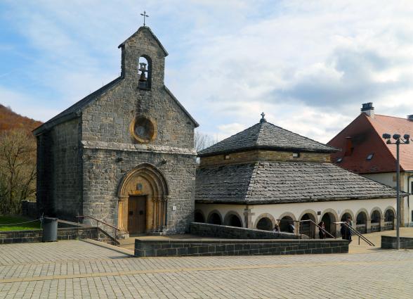 Real Colegiata de Roncesvalles con iglesia gótica de piedra, claustro románico y cruz en cumbre, Pirineo navarro.