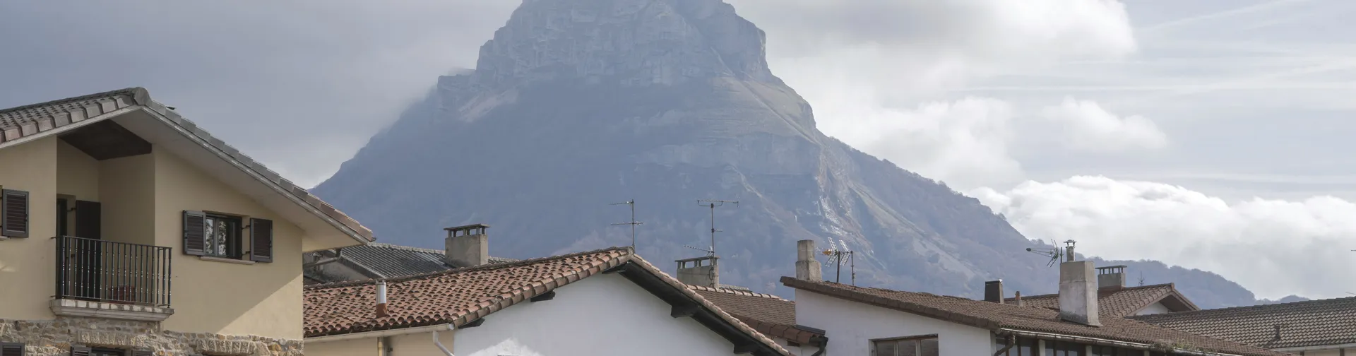 Casas tradicionales de Arbizu, dominadas por la silueta del monte Beriain al fondo.