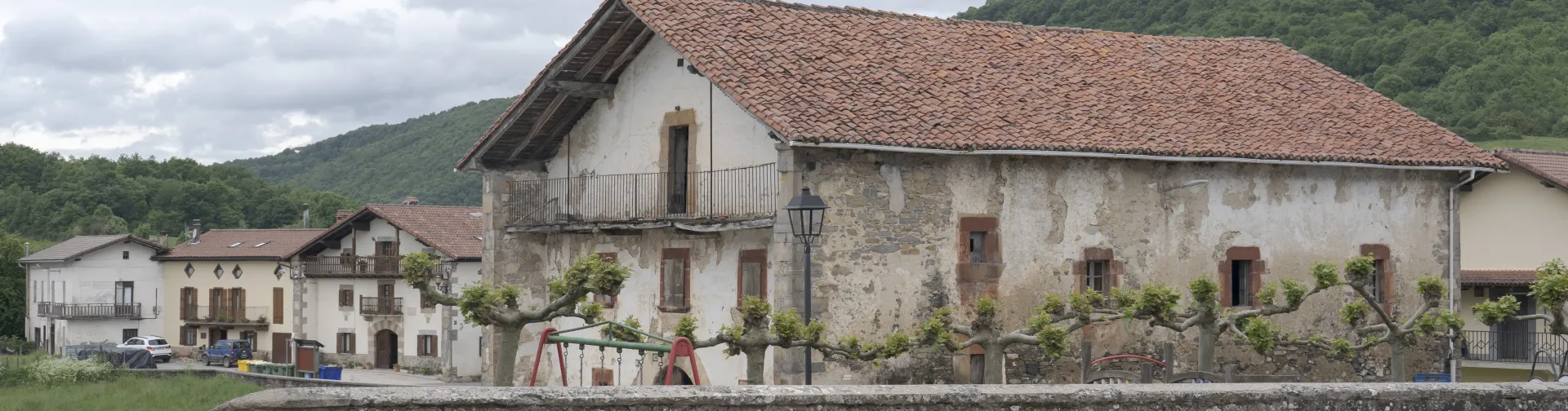 Caserío tradicional en Bizkarreta-Gerendiain, con balconada de madera, junto a plaza del frontón.