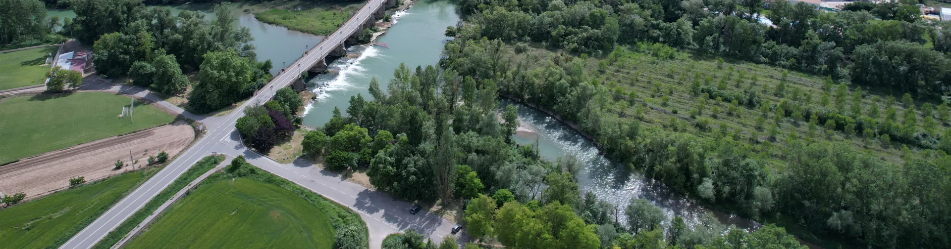 Vista aérea de Cáseda con río Aragón, prados verdes y montes boscosos.