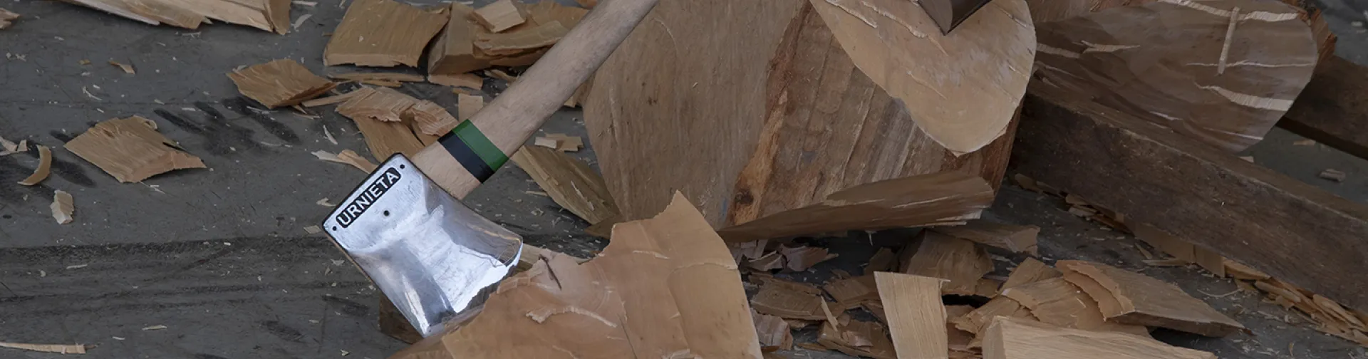 Hachas sobre troncos de madera con virutas en Ezkurra