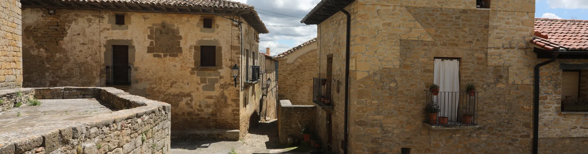 Casas de piedra arenisca en Gallipienzo con tejados de teja curva y muros de piedra.