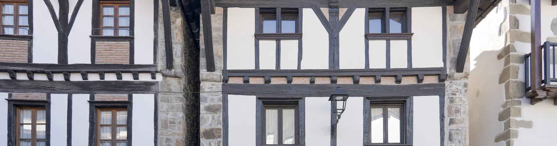 Casas de entramado de madera y piedra en Goizueta, con fachadas blancas, vigas oscuras y ventanas tradicionales.