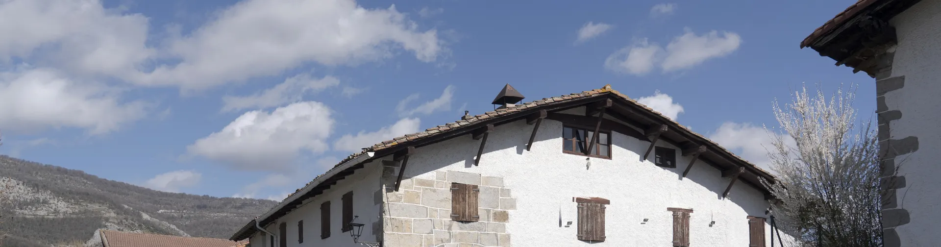 Conjunto de casas tradicionales blancas en Irañeta, rodeado de montañas calizas.