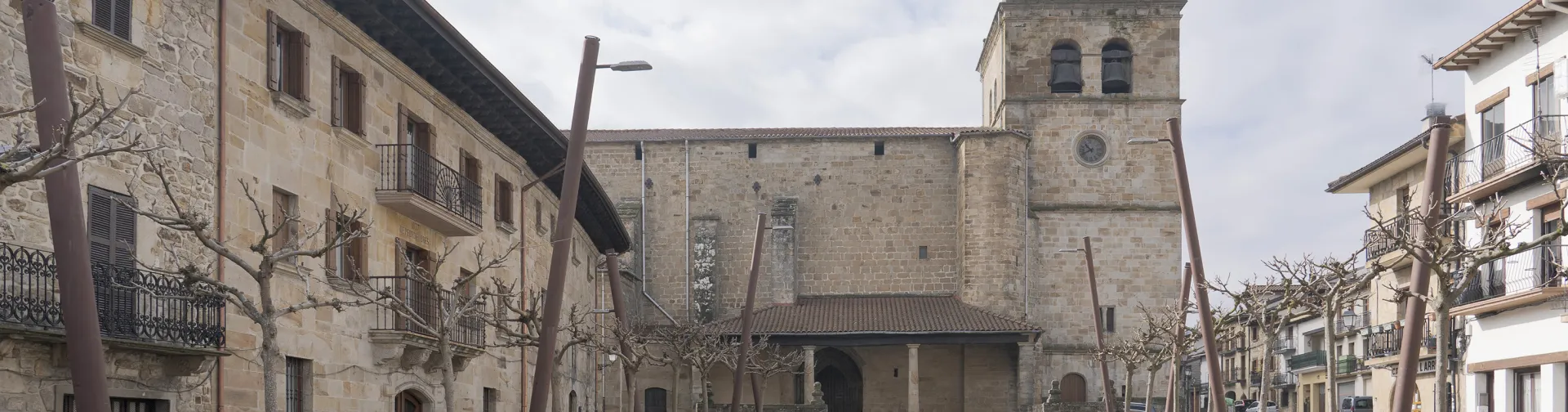 Plaza de Lakuntza con arquitectura tradicional, montañas de fondo y conjunto de casas a los lados.