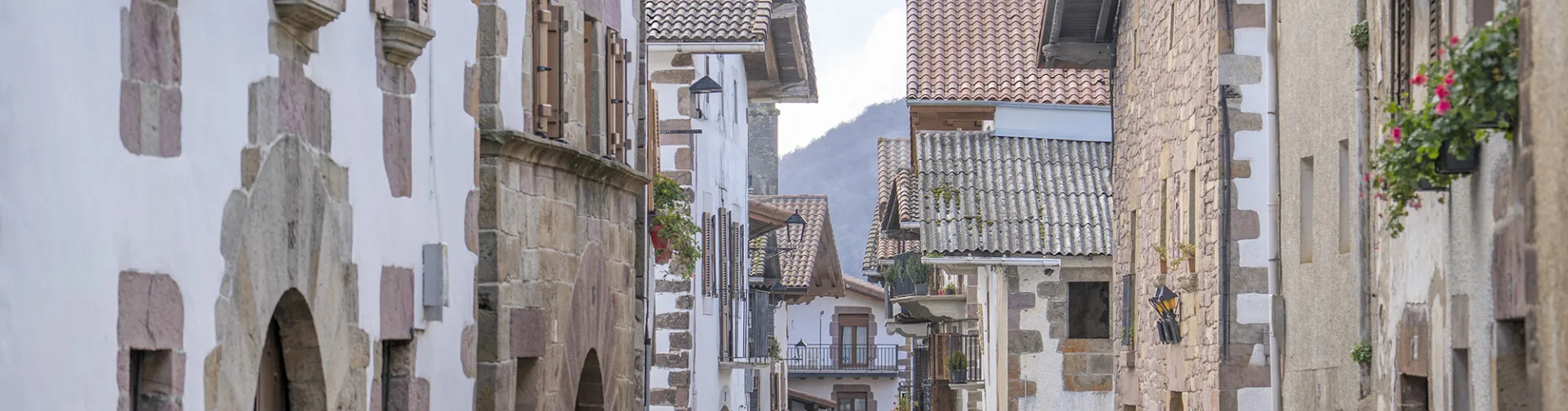 Calle de Lantz con casas de piedra blanca, puertas de madera y balcones tradicionales.