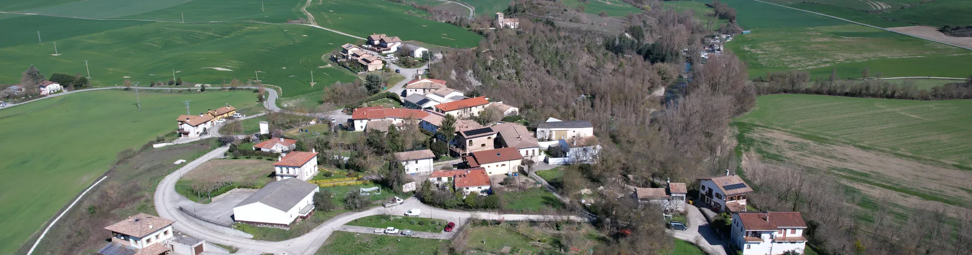Vista aérea de Lizoain-Arriasgoiti con casas dispersas, campos verdes y bosques.