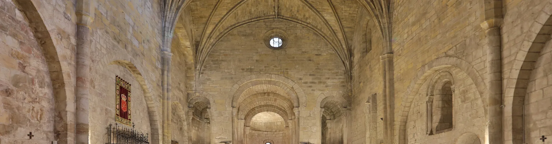 Interior de la nave central del Monasterio de Leyre con bóvedas de cañón y columnas de piedra.