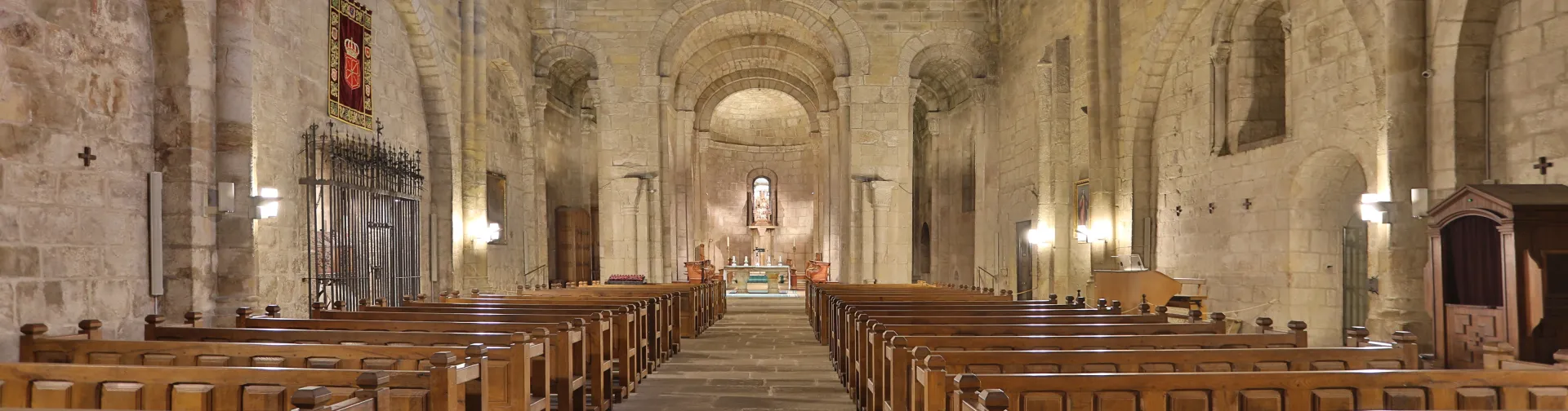 Interior de la nave central del Monasterio de Leyre con bóvedas de cañón y columnas de piedra.