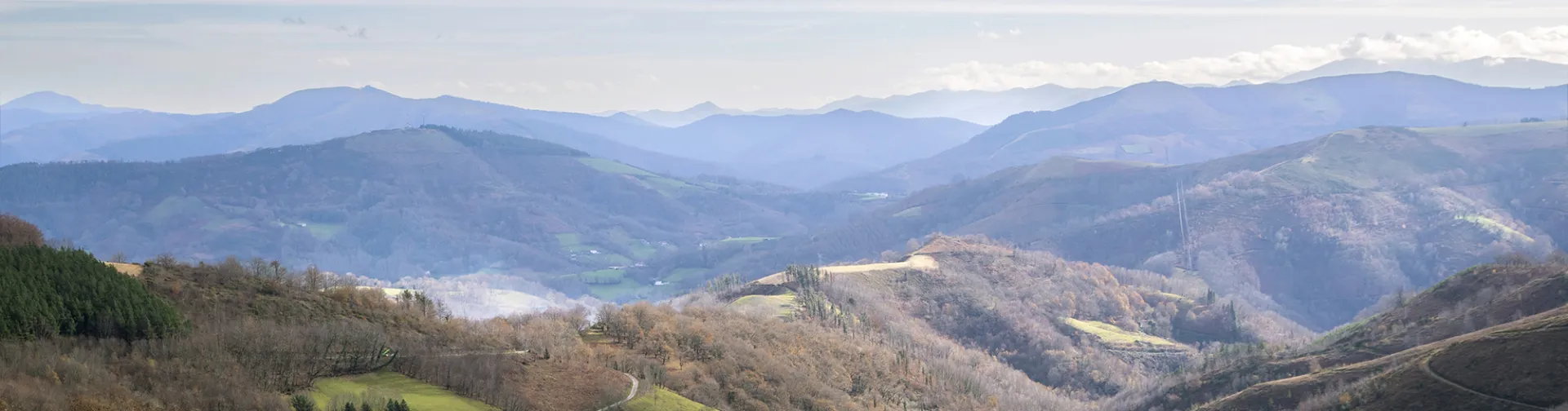 Valle verde con caserio tradicional y montaña al fondo en los valles de Baztan Bidasoa.