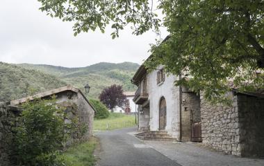 Calle de Antxoriz, Pirineo de Navarra, con casas de piedra y monte al fondo.