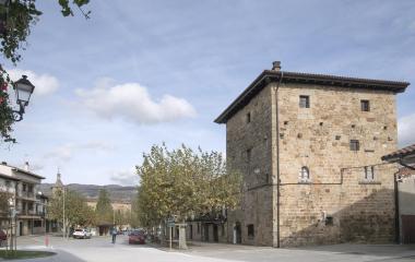 Plaza de Arbizu con arquitectura de piedra medieval, torre fortificada y casas tradicionales.