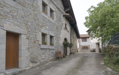Calle con caserio tradicional de piedra en Ardaitz, Pirineo navarro, con fachada de mamposteria y puerta de madera.