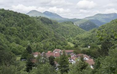 Valle pirenaico con vista de Azparren, caseríos tradicionales navarros rodeados de montañas.