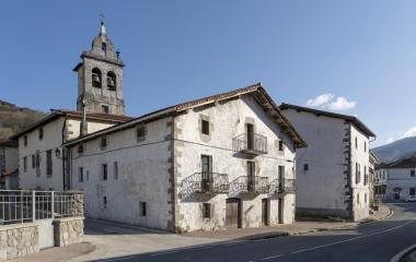 Conjunto de casas tradiconales blancas en Betelu, por arriba asoma el campanario.