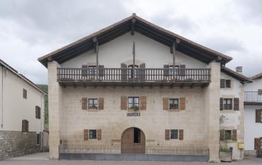 Casa palacio de piedra arenisca con balconada de madera en Bizkarreta-Gerendiain, Pirineo de Navarra.