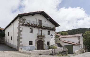 Casa tradicional de piedra con balconadas de hierro en Errea, Pirineo navarro.