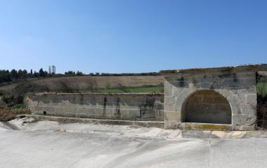 Construcciones de piedra con bóveda de tunel, rodeadas de campos de cultivo y vegetacion.