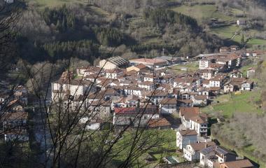 Vista aérea de Goizueta con casas de arquitectura tradicional navarra, rodeadas de bosque y prados verdes en el valle.