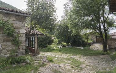 Casas de piedra en Lacabe, Pirineo Navarro, rodeadas de vegetación..