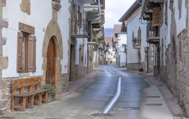 Calle de Lantz con casas de piedra blanca, puertas de madera y balcones tradicionales.