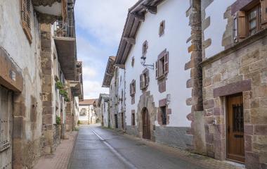 Calle de Lantz con casas de piedra blanca, puertas de madera y balcones tradicionales.