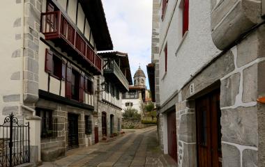 Calle de Lesaka con casas de piedra, iglesia al fondo en Baztan-Bidasoa.