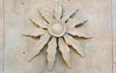 Detalle floral esculpida en piedra en Longuida, con motivo de eguzkilore.