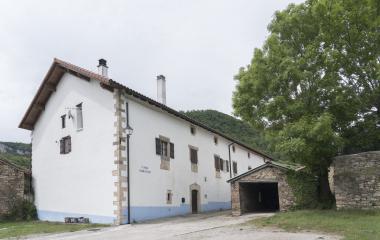 Casa Garakiko de arquitectura tradicional en Lusarreta, Pirineo navarro, con fachada blanca, piedra y franja azul característica.