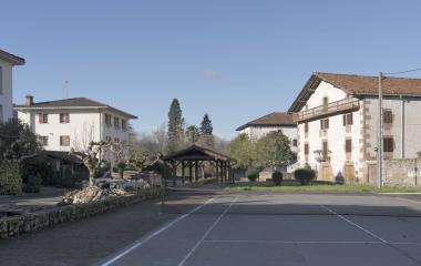 Herriko plaza, tenis pistarekin eta euskal etxe zuriekin Oieregi inguruan.