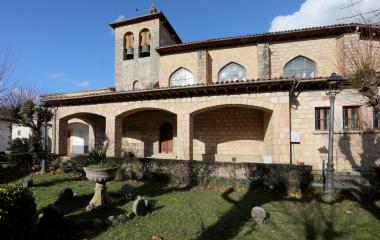 Iglesia de piedra con campanario, arcos  y porticada románica en Oroz-Betelu.